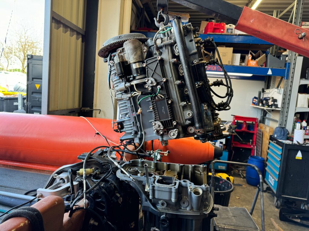 Dépose du bloc moteur d’un hors-bord à la grue d’atelier chez Nautique Services à La Rochelle