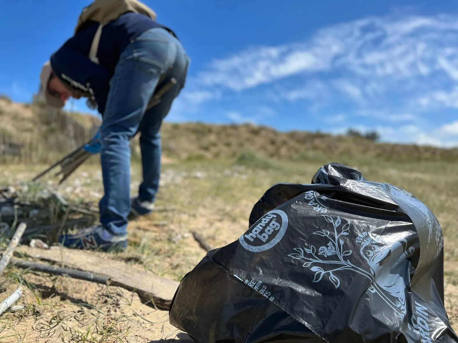 Bénévole ramassant des déchets dans les dunes d’Aytré