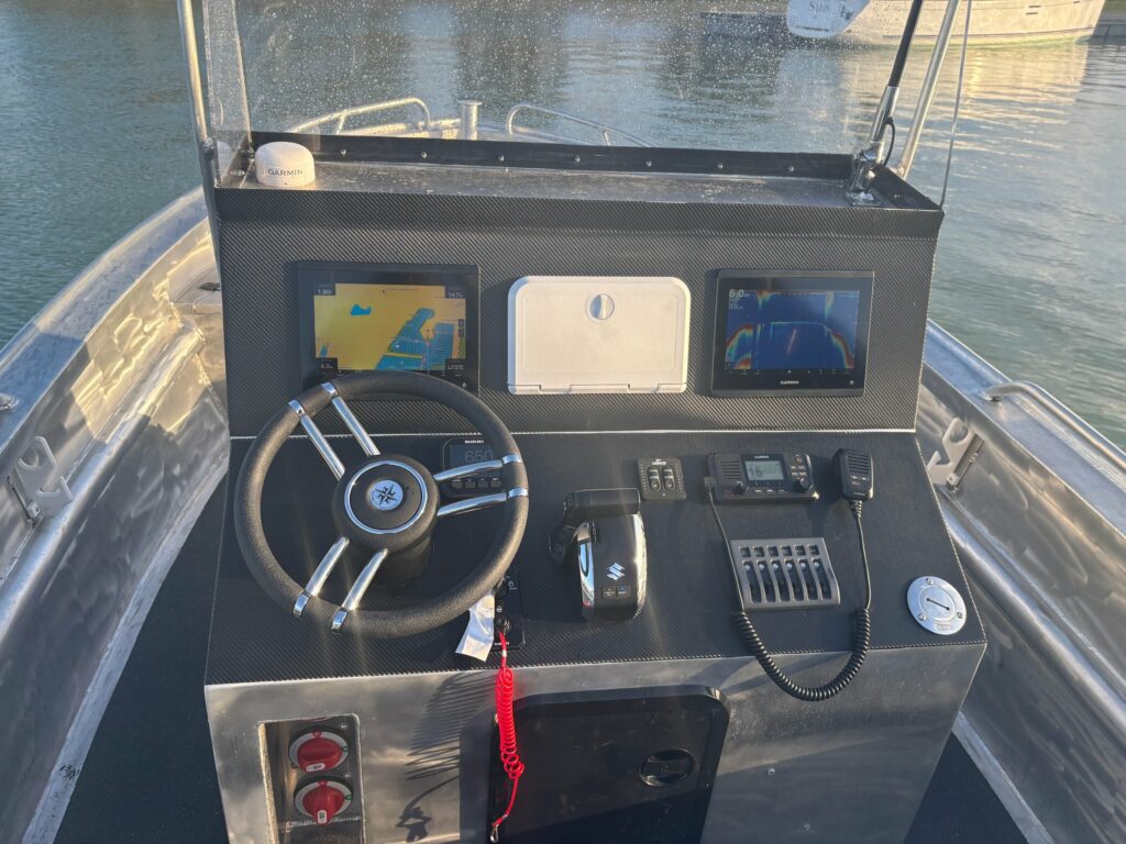 Console terminée : écrans Garmin, VHF Garmin, commande Suzuki et flaps Lenco montés par Nautique Services