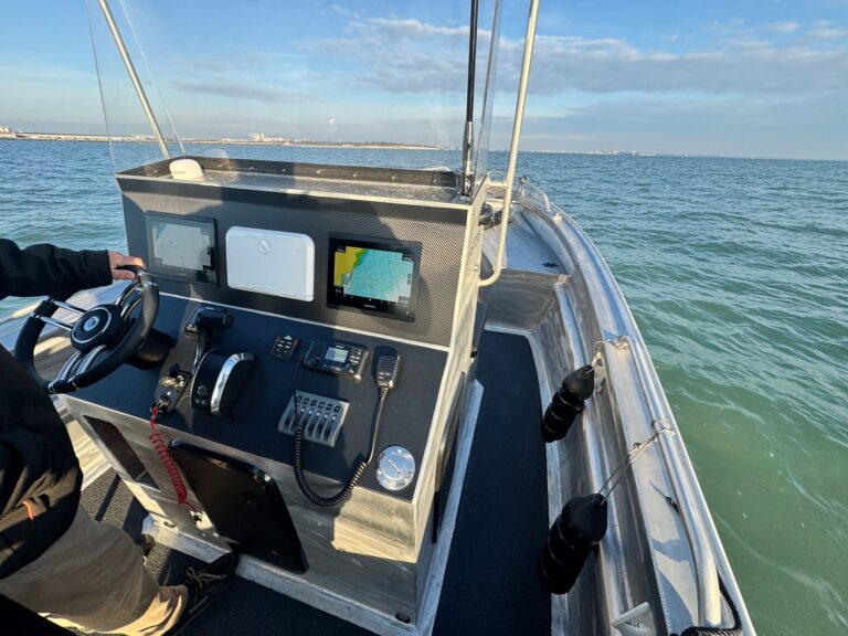 Console aluminium équipée par Nautique Services : deux écrans Garmin, VHF et commande Suzuki, en navigation devant La Rochelle