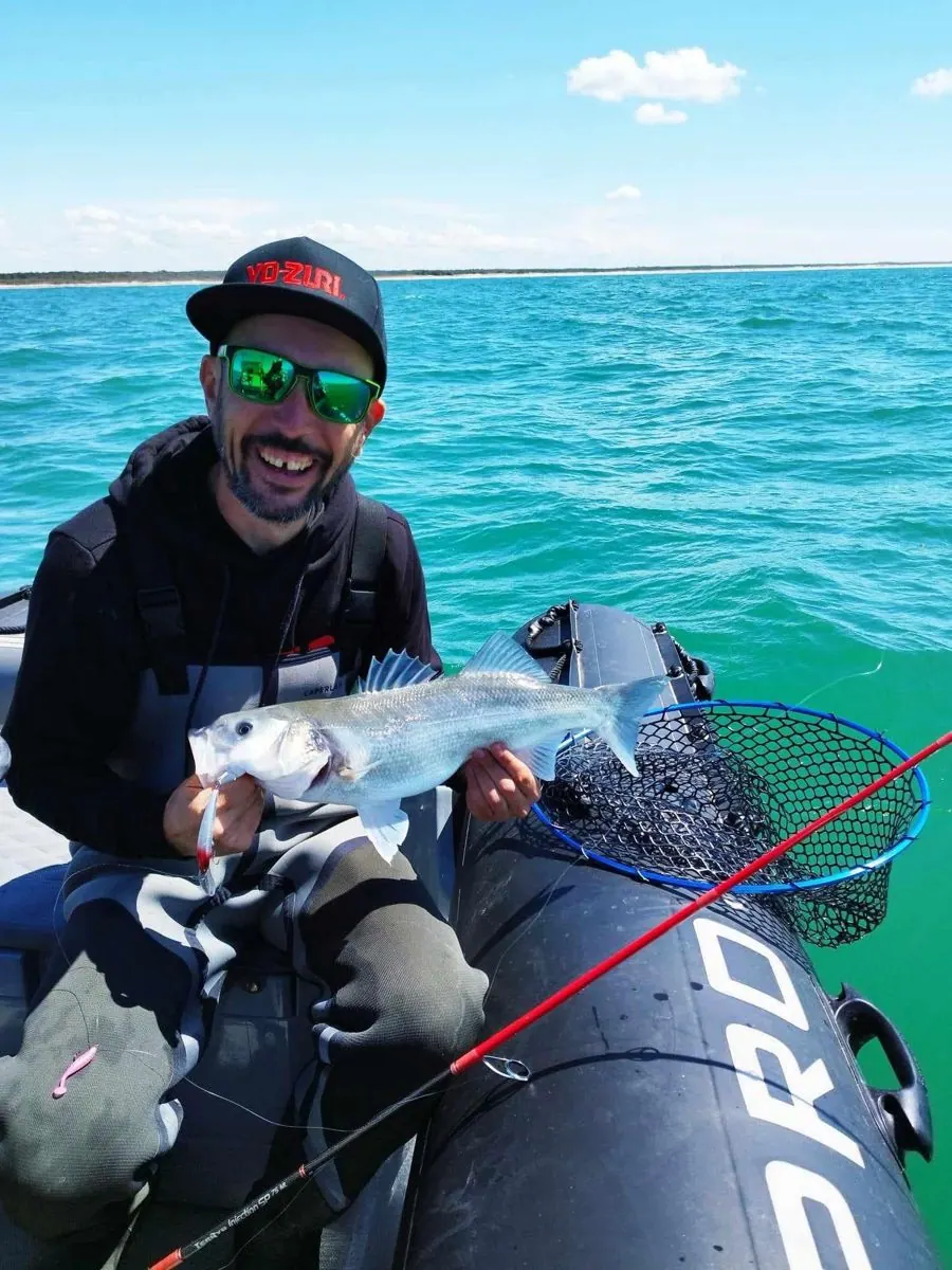 Vincent Armengaudo tenant un bar pêché au leurre à bord